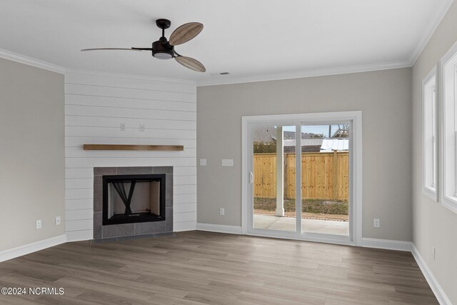 unfurnished living room with hardwood / wood-style flooring, ceiling fan, crown molding, and a fireplace