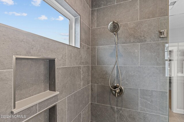 interior details featuring tiled shower