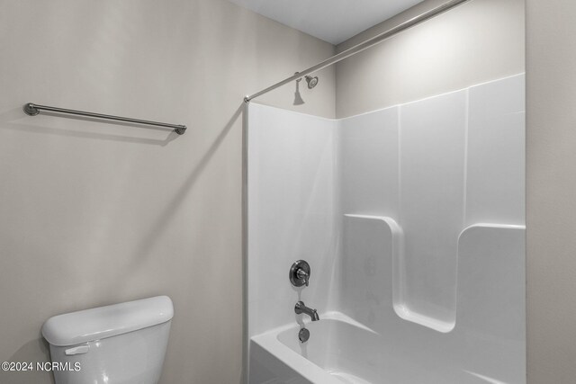 bathroom featuring shower / bathing tub combination and toilet