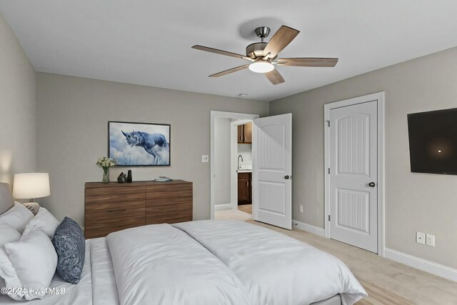 unfurnished bedroom featuring ceiling fan, sink, and light carpet