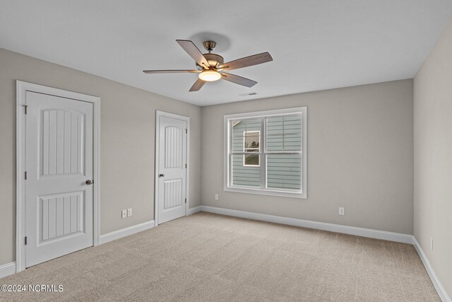 unfurnished bedroom featuring light carpet and ceiling fan