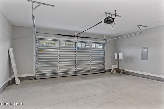 garage with electric panel and a garage door opener