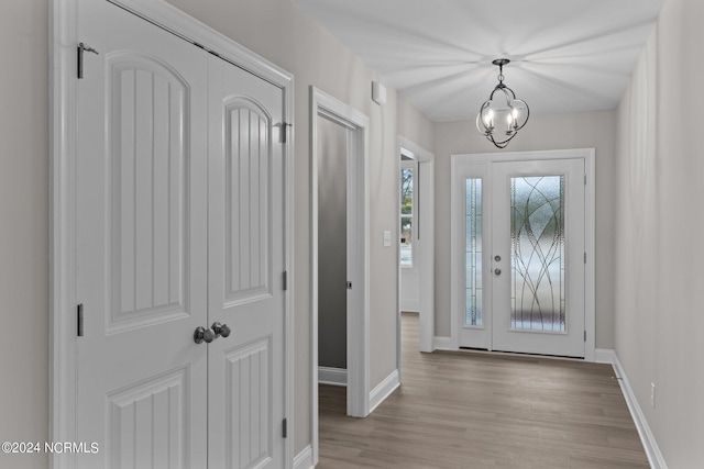 entrance foyer with light hardwood / wood-style flooring and a chandelier