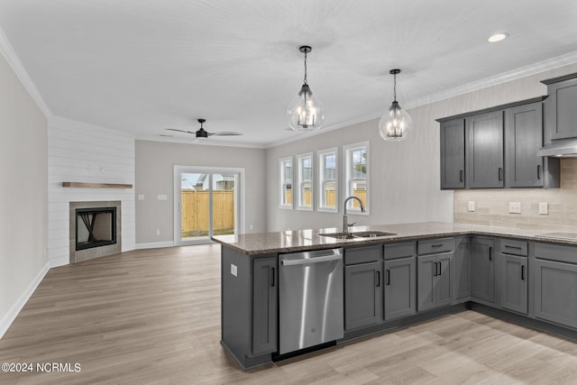 kitchen with ceiling fan, dishwasher, sink, decorative light fixtures, and a fireplace