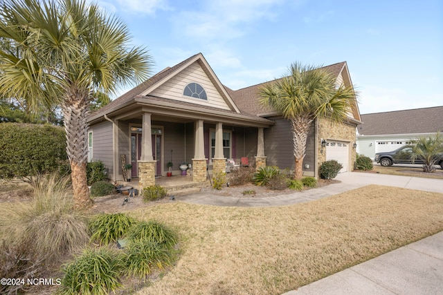 view of front facade with a garage, covered porch, and a front yard