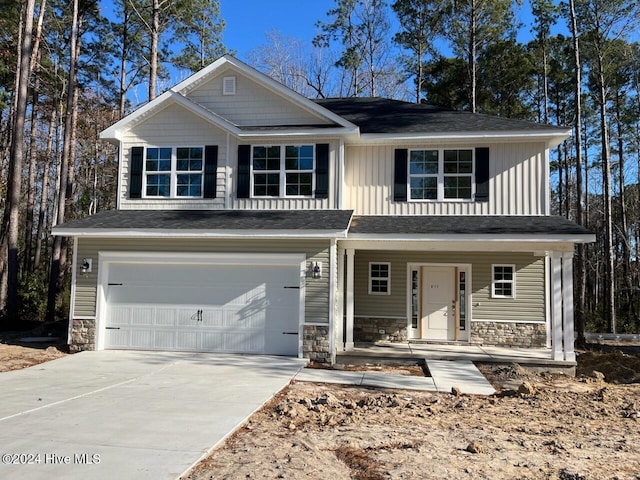 view of front of home featuring covered porch, concrete driveway, an attached garage, board and batten siding, and stone siding