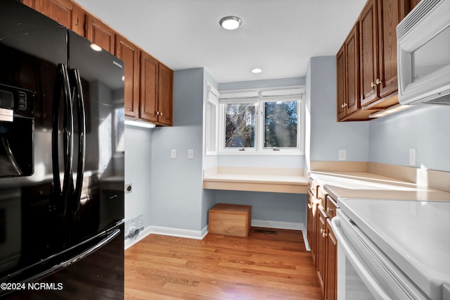 kitchen with white appliances and light hardwood / wood-style floors