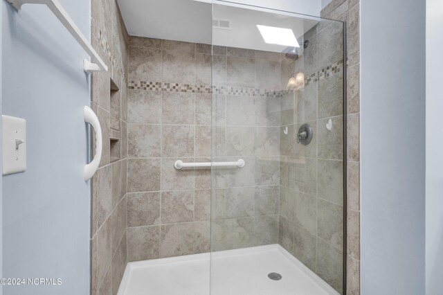 bathroom featuring tile flooring, large vanity, toilet, and tiled shower