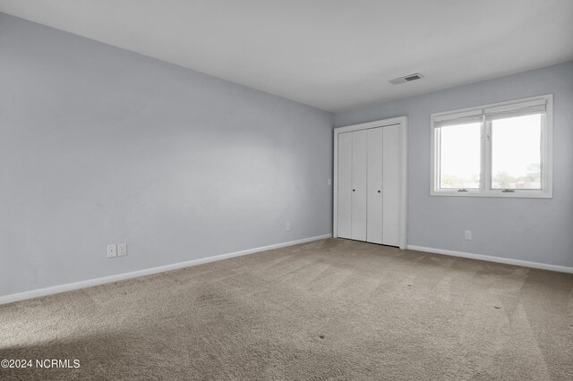 unfurnished bedroom featuring connected bathroom and light colored carpet