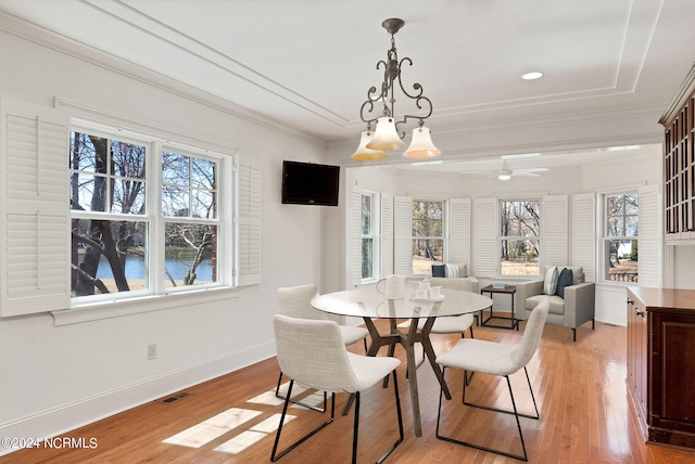 dining room with ornamental molding, ceiling fan with notable chandelier, and light hardwood / wood-style flooring