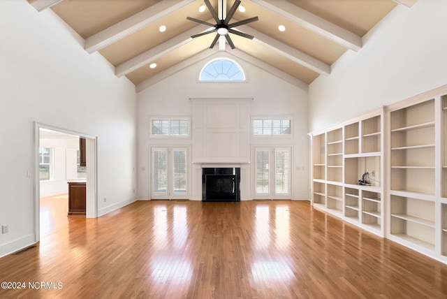 unfurnished living room featuring high vaulted ceiling, a wealth of natural light, beam ceiling, and ceiling fan