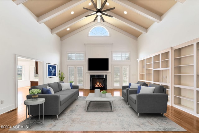 living room with plenty of natural light, high vaulted ceiling, ceiling fan, and hardwood / wood-style flooring