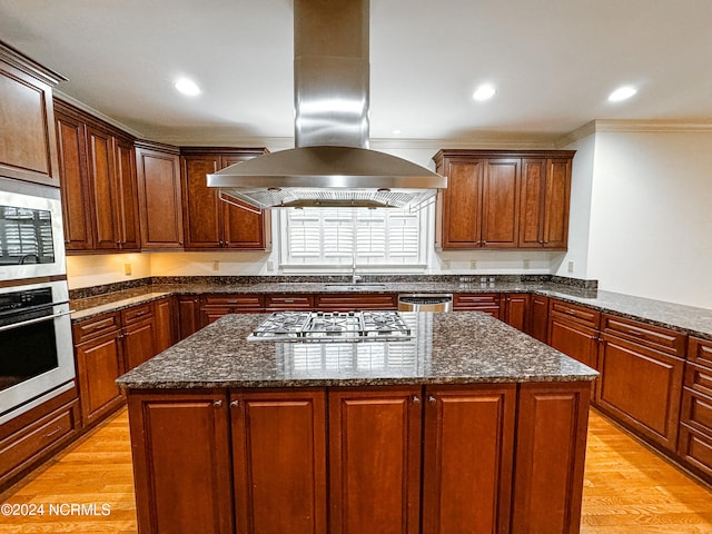 kitchen featuring light hardwood / wood-style floors, crown molding, appliances with stainless steel finishes, and island exhaust hood