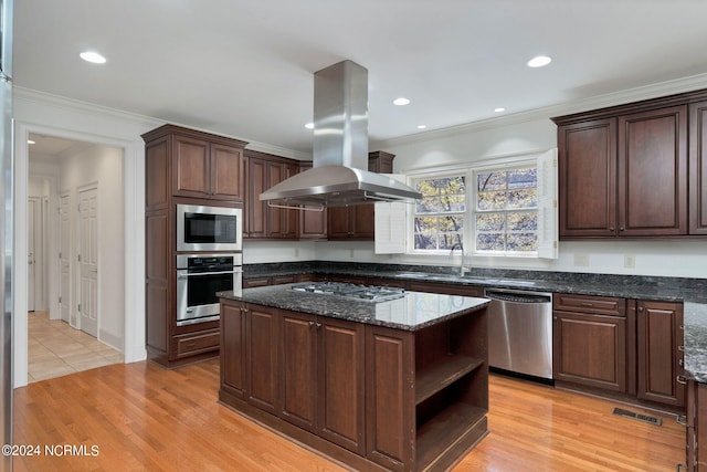 kitchen with appliances with stainless steel finishes, light tile floors, dark stone counters, a kitchen island, and island exhaust hood