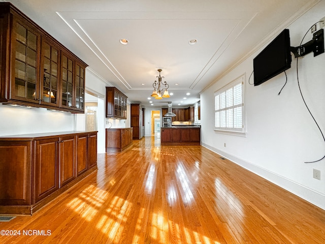 interior space with an inviting chandelier, light wood-type flooring, and ornamental molding