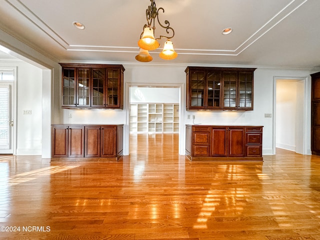 unfurnished living room featuring ornamental molding, a chandelier, and light hardwood / wood-style floors