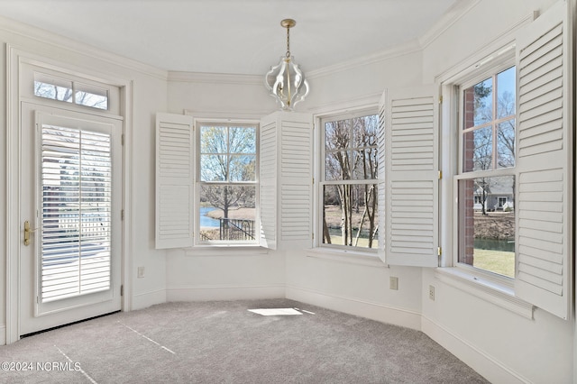 unfurnished room with an inviting chandelier, light carpet, and crown molding