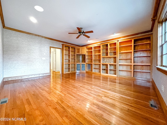 interior space featuring built in shelves, ceiling fan, ornamental molding, and light wood-type flooring