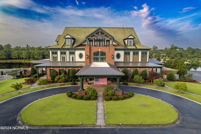 view of front of property with a water view, a front lawn, and a gazebo