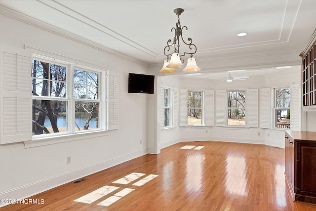 interior space featuring plenty of natural light, light hardwood / wood-style floors, ornamental molding, and ceiling fan with notable chandelier