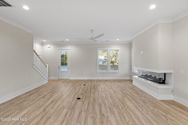 unfurnished living room with a multi sided fireplace, light wood-type flooring, and crown molding