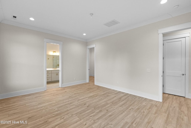 unfurnished bedroom featuring ensuite bathroom, light hardwood / wood-style flooring, and ornamental molding