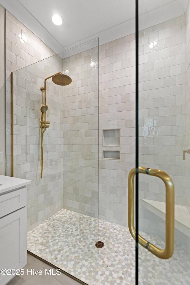 bathroom with vanity and a shower with door