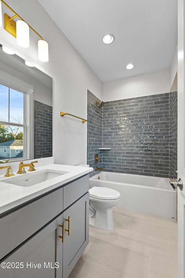 full bathroom featuring tile patterned flooring, vanity, toilet, and tiled shower / bath