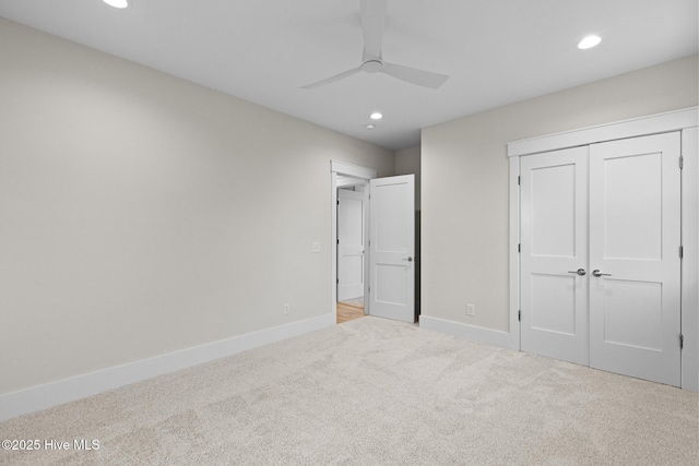 unfurnished bedroom featuring a closet, light colored carpet, and ceiling fan