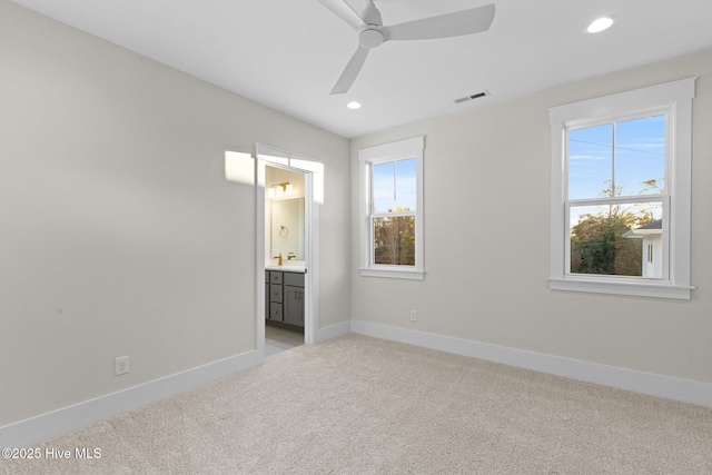 carpeted spare room featuring ceiling fan