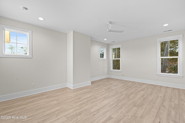 spare room featuring ceiling fan, a wealth of natural light, and light hardwood / wood-style flooring