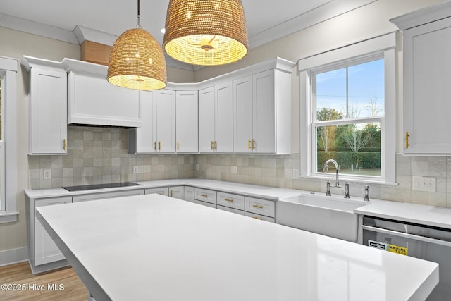 kitchen with dishwasher, sink, hanging light fixtures, tasteful backsplash, and black electric stovetop