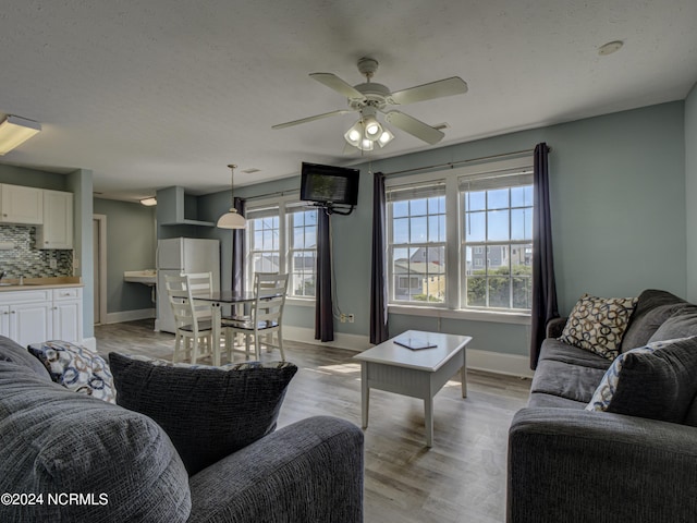 living room featuring ceiling fan and light hardwood / wood-style flooring