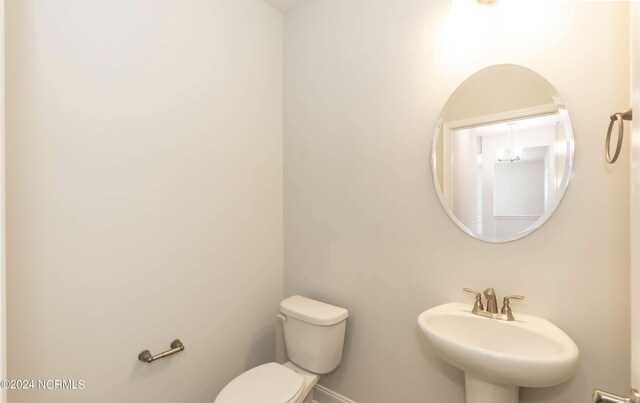 1225 Mandevilla Dr SE, Bolivia, NC 28422 - half bathroom with a sink, toilet, and baseboards