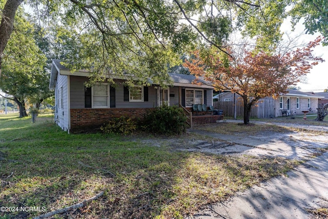 view of front of house with a front yard and covered porch