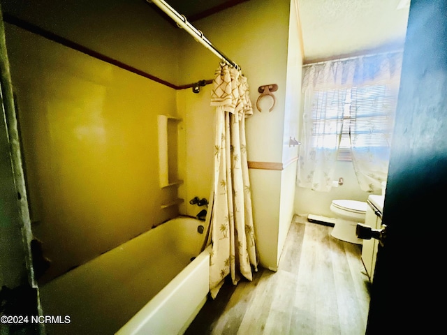 bathroom featuring toilet, hardwood / wood-style floors, and shower / bath combo with shower curtain