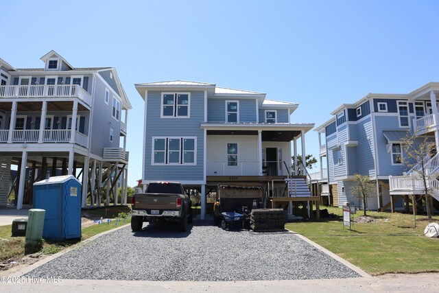 exterior space with metal roof, driveway, stairway, and a carport