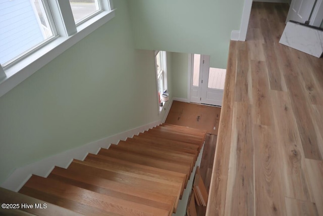 stairs featuring baseboards and wood finished floors