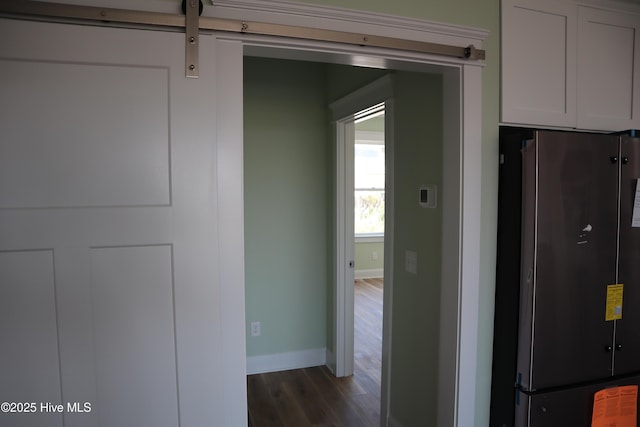 corridor featuring baseboards and wood finished floors