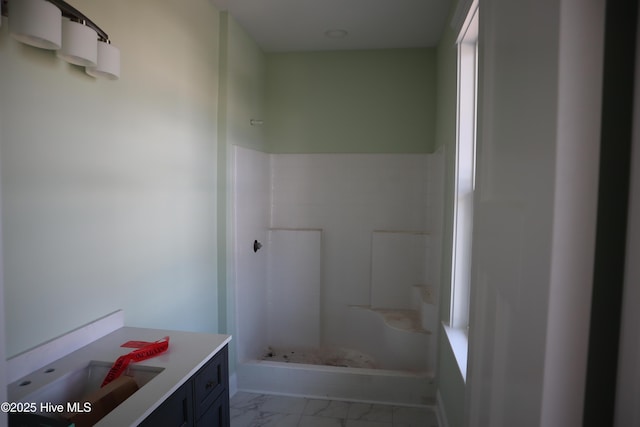 full bathroom featuring vanity, marble finish floor, and a shower
