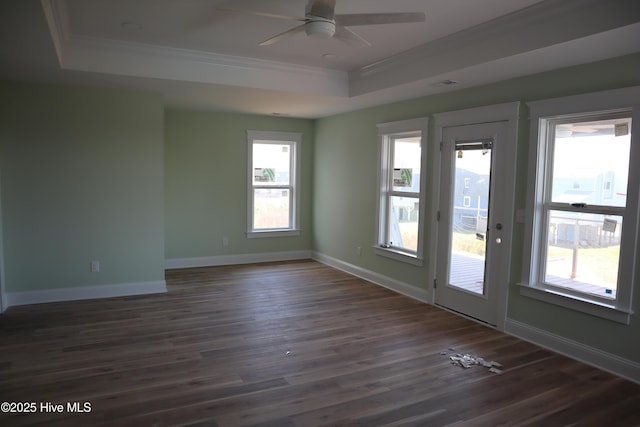 unfurnished room with a ceiling fan, ornamental molding, a tray ceiling, baseboards, and dark wood-style flooring