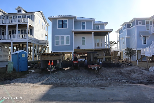 exterior space with metal roof, a carport, and dirt driveway