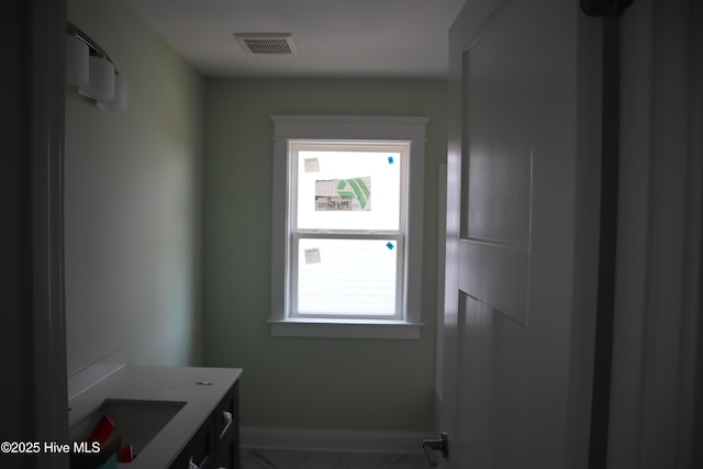doorway to outside featuring baseboards, visible vents, and marble finish floor