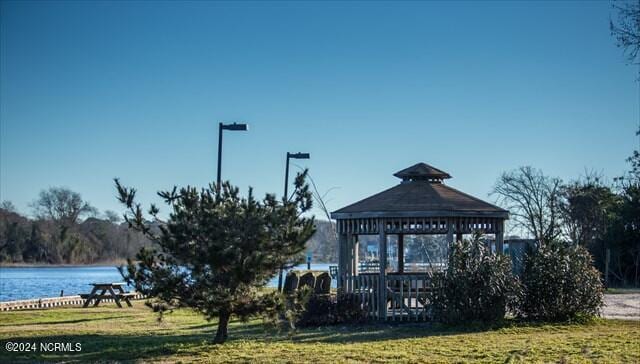 surrounding community featuring a gazebo, a water view, and a lawn