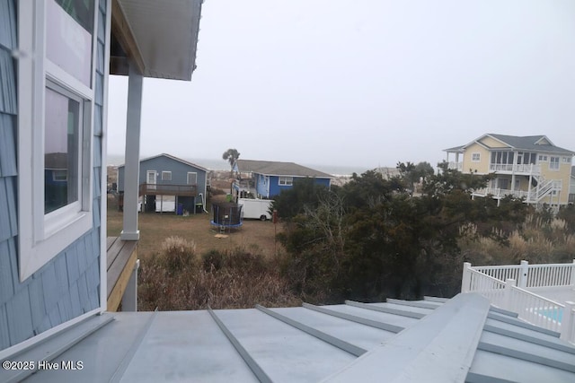 view of yard featuring a trampoline and a residential view