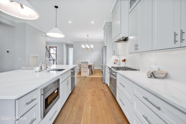 kitchen featuring white cabinets, pendant lighting, high end appliances, and crown molding