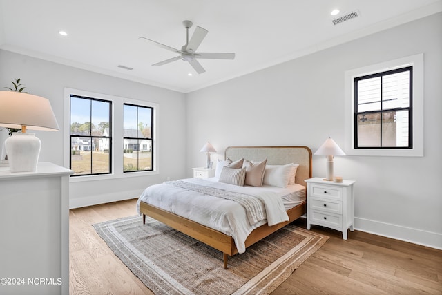 bedroom with light wood-type flooring, ceiling fan, and crown molding