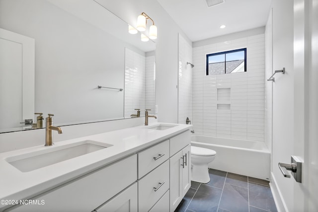 full bathroom featuring tile patterned floors, vanity, tiled shower / bath combo, and toilet