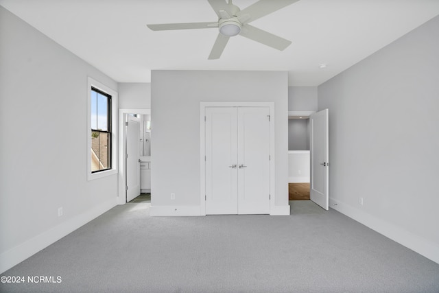 unfurnished bedroom featuring ensuite bath, ceiling fan, a closet, and light carpet