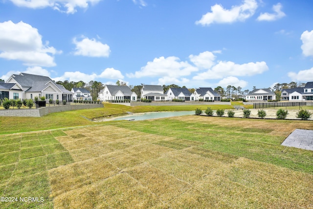 view of property's community with a yard and a water view